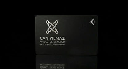 a black rectangular card with a white logo and text on it, placed on a reflective surface against a black background.