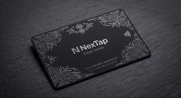 A black rectangular business card with a decorative border and text, placed on a dark surface.