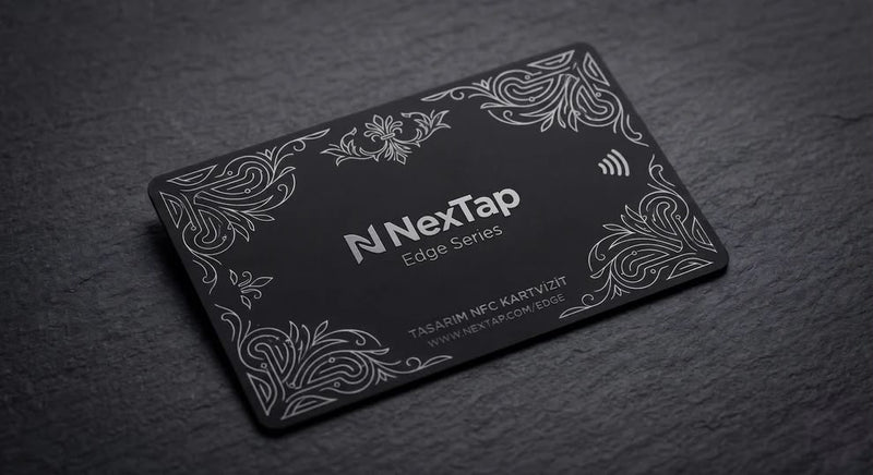 A black rectangular business card with a decorative border and text, placed on a dark surface.