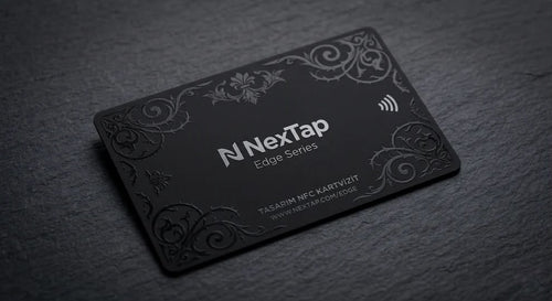 A black rectangular business card with embossed designs and text, resting on a dark surface.